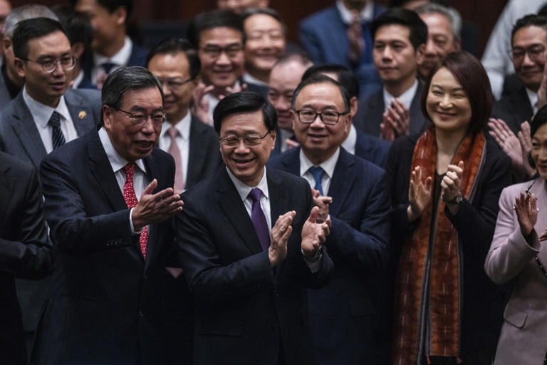 Hong Kong's Chief Executive John Lee Ka-chiu applauds with lawmakers following the passing of the Basic Law Article 23 legislation at the Legislative Council in Hong Kong, Tuesday, March 19, 2024. (AP Photo/Louise Delmotte)
© Provided by The Associated Press